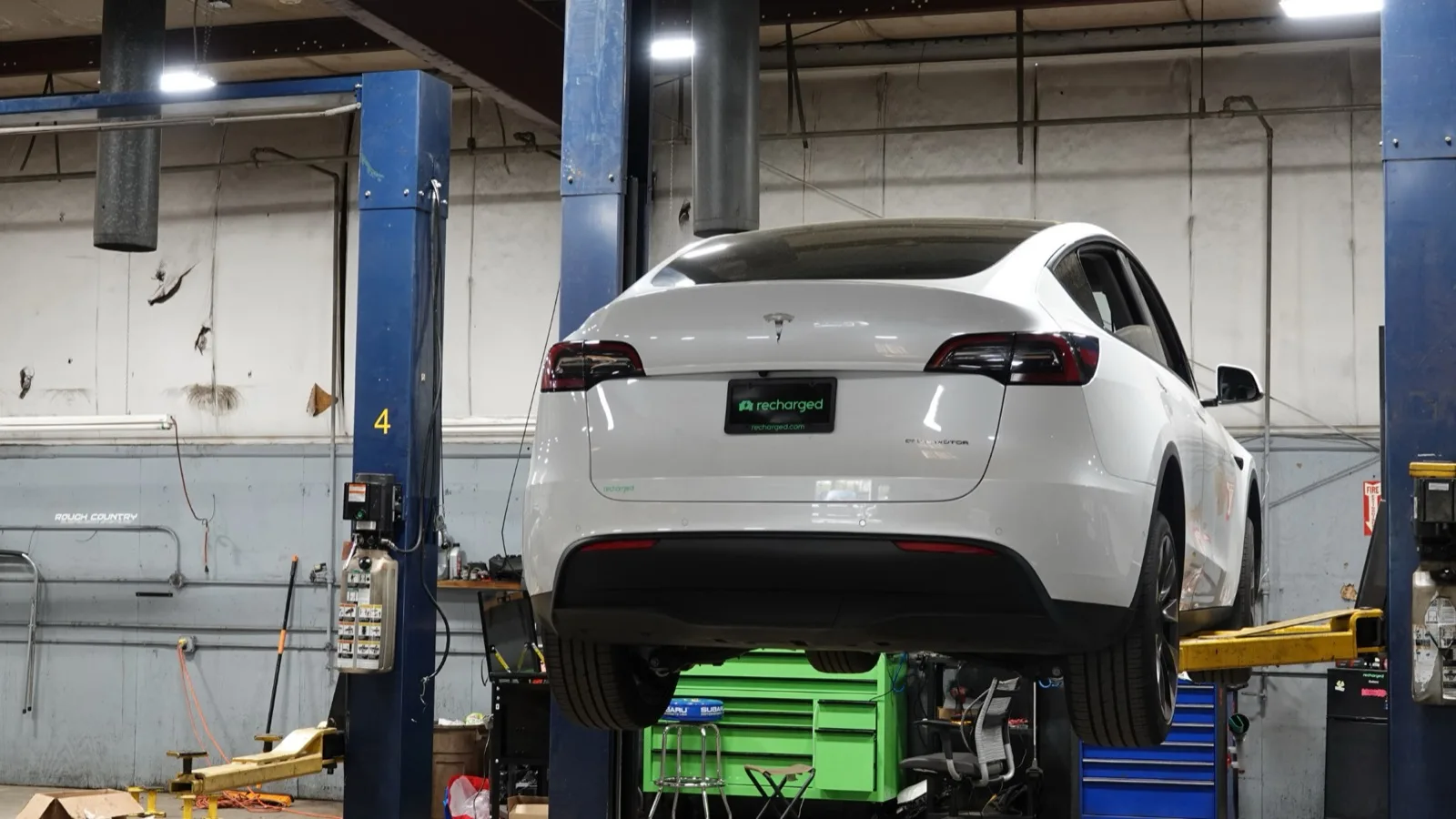 Tesla Model Y on a lift in the Recharged reconditioning center