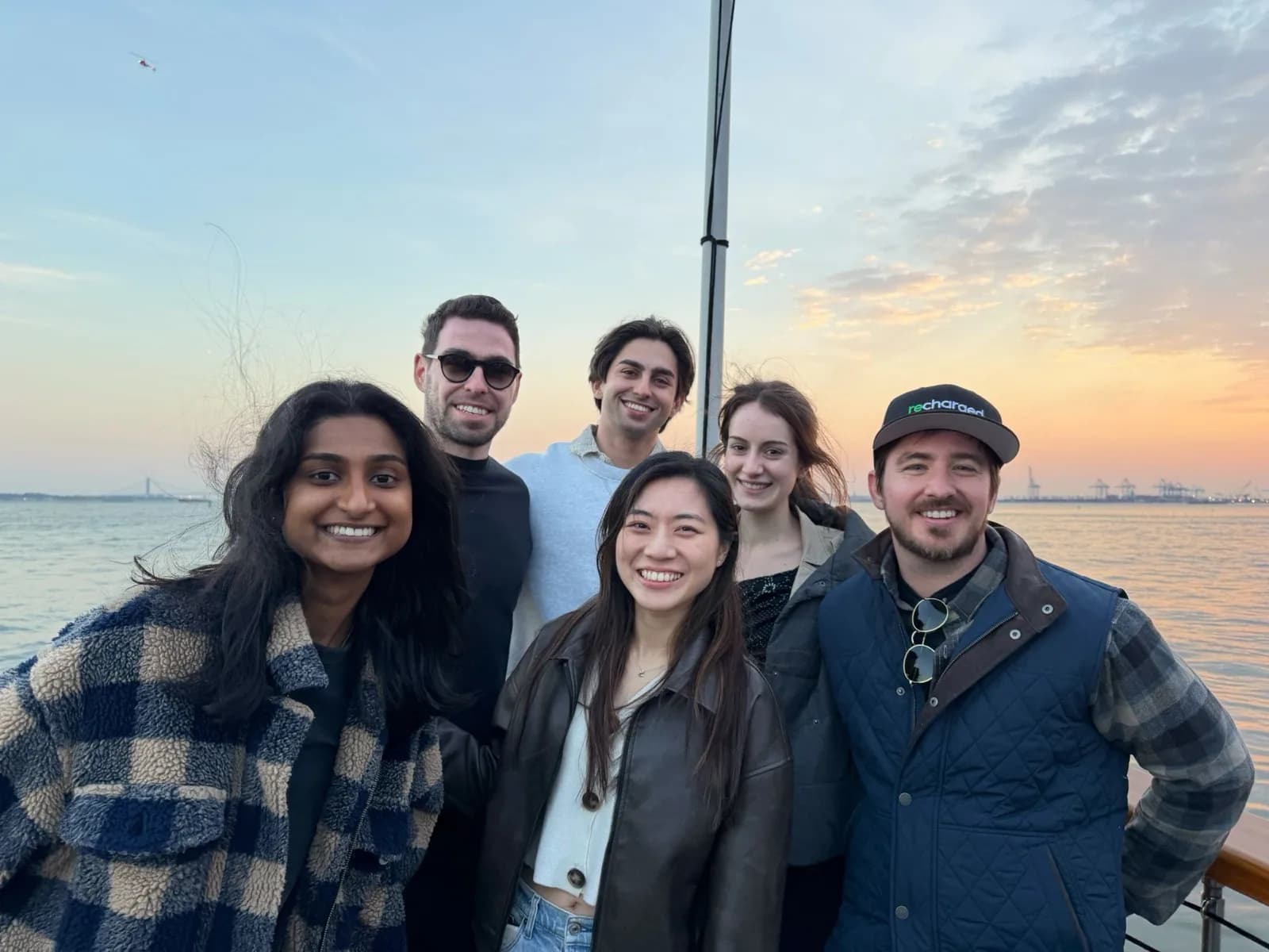 Recharged team members on a boat at sunset in New York Harbor